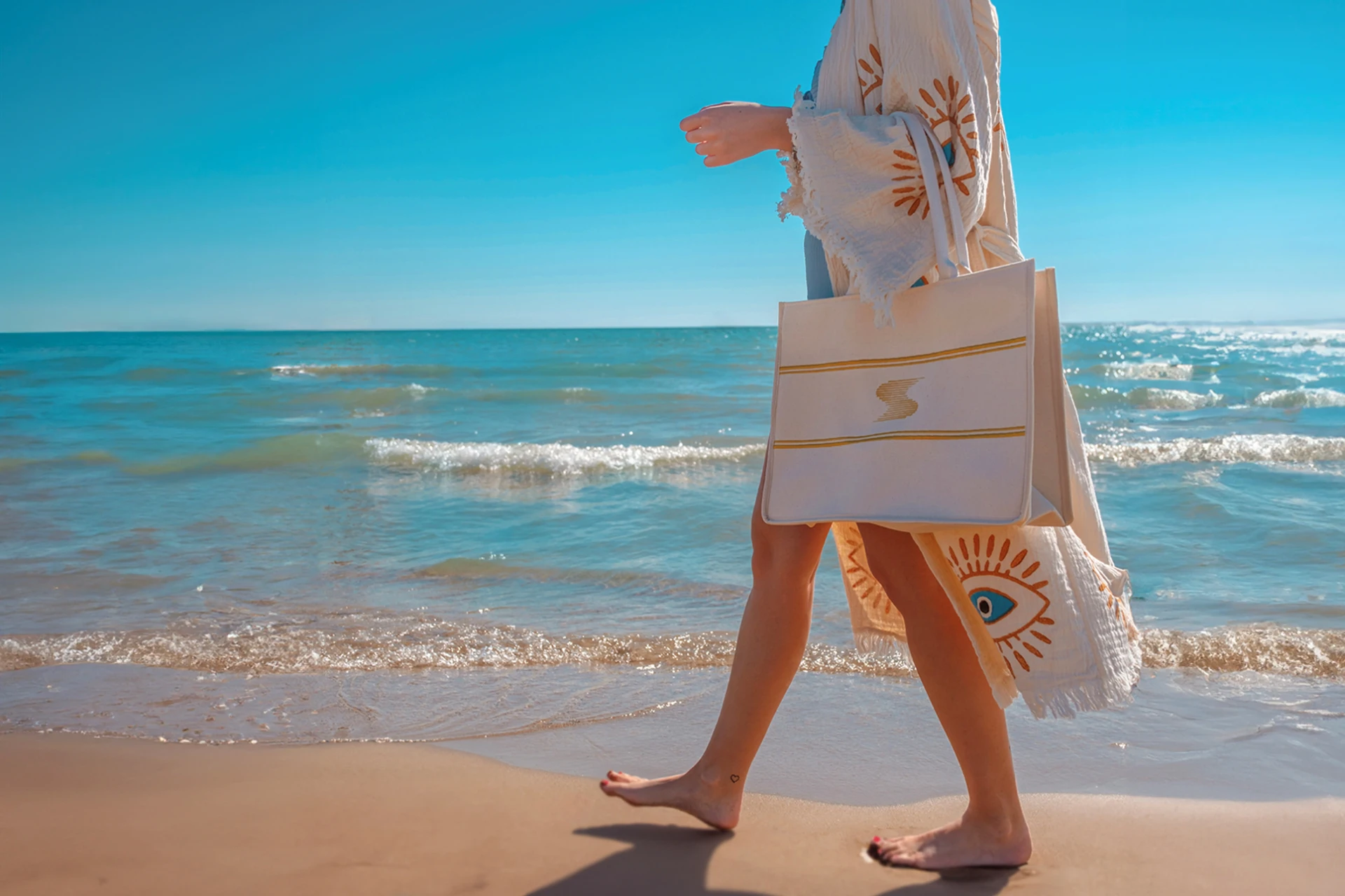 Guest walking along the beach at Bella Resort & Spa